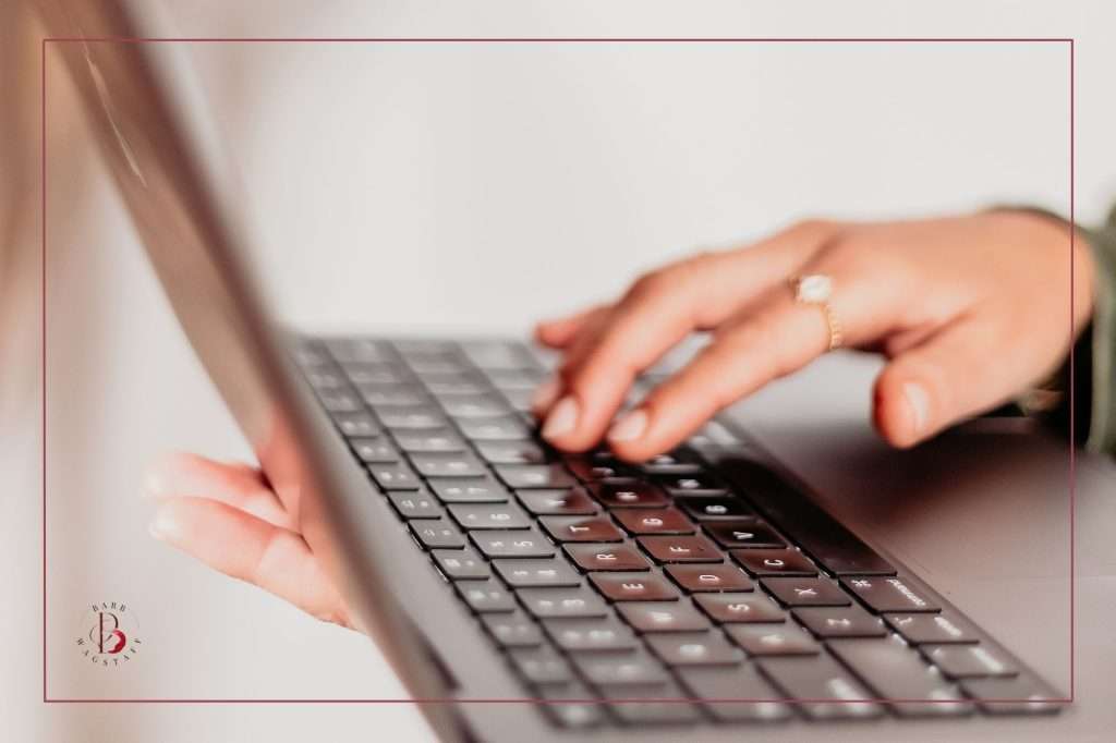 woman's hands on her laptop keyboard