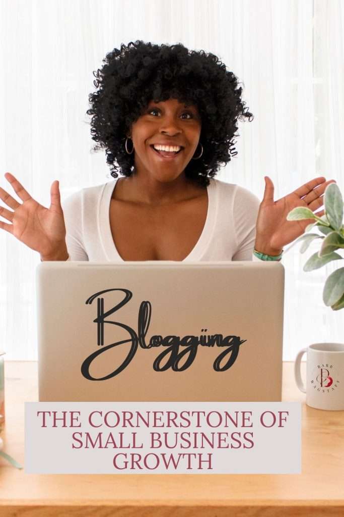 black woman with her hands in the air and a smile on her face, sitting in front of her laptop. On the back of the laptop is the text "blogging: The cornerstone of small business growth"